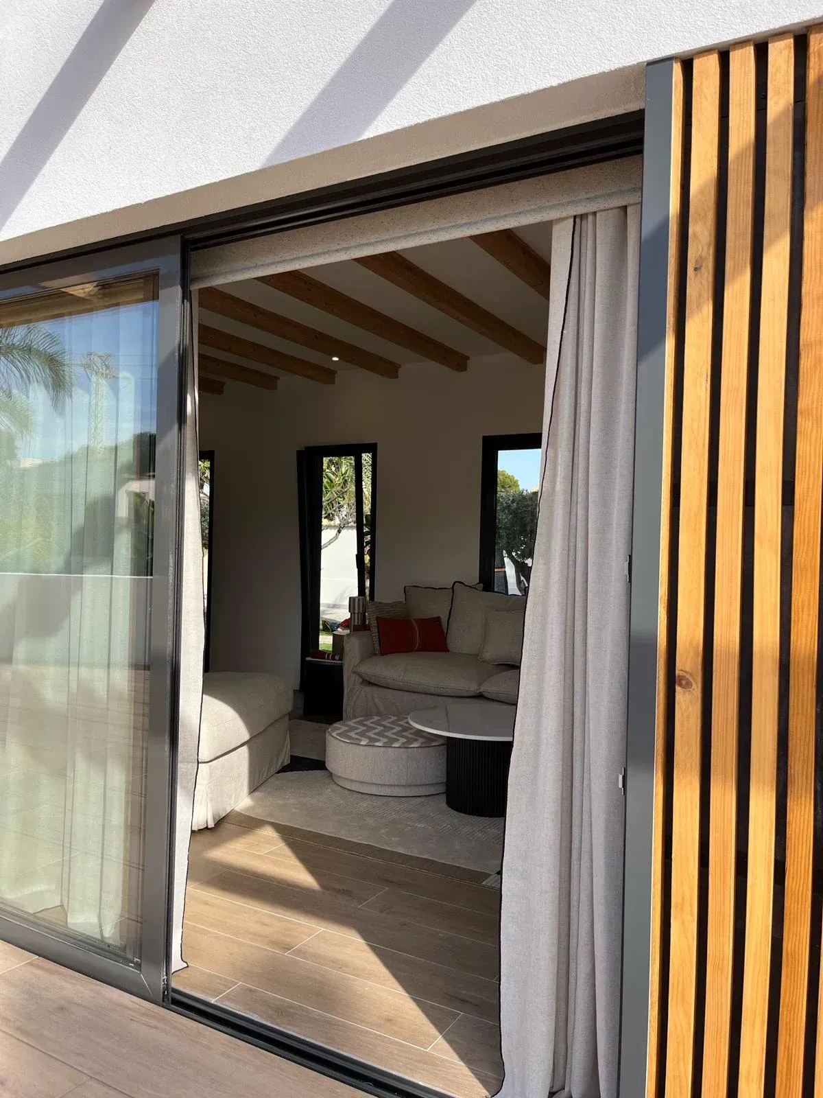 Una puerta corrediza de vidrio se abre a una sala de estar.