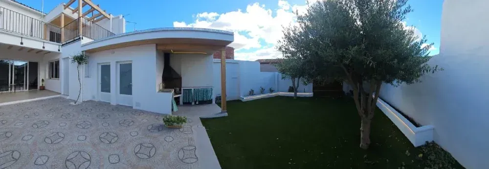 Una casa blanca con un gran jardín delante de ella.