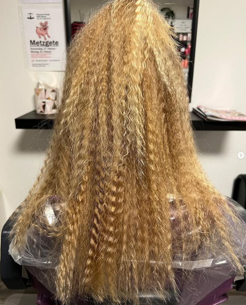 Blondes Haar, das in einem Salon mit einem Crimpeisen gestylt wurde.