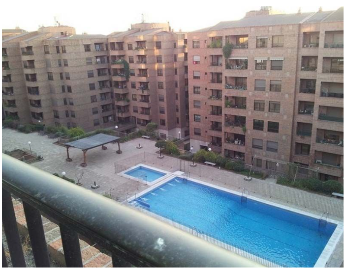 Un gran edificio con una piscina en frente.