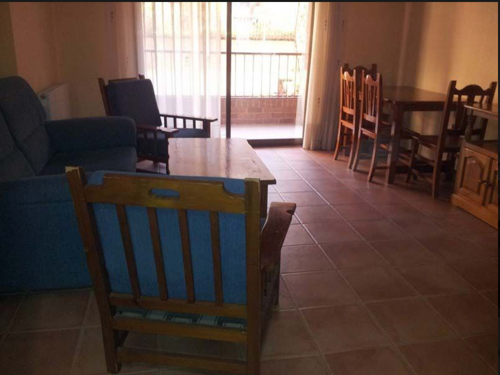 Una sala de estar con un sofá y sillas y una mesa.