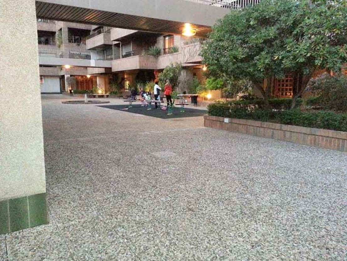 Un grupo de personas está de pie en un patio frente a un edificio.