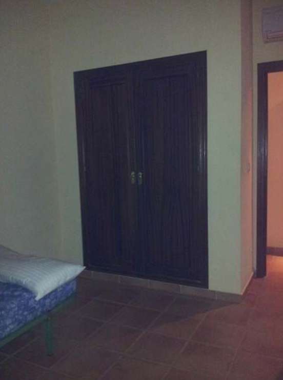 Un dormitorio con un armario y una cama dentro.