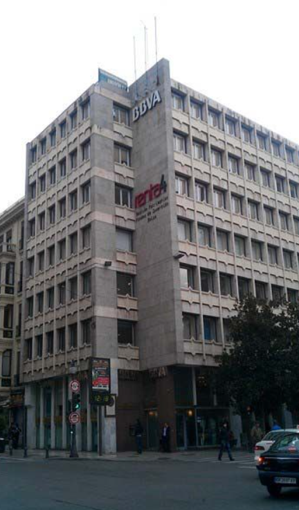 Un edificio grande con muchas ventanas y un cartel que dice