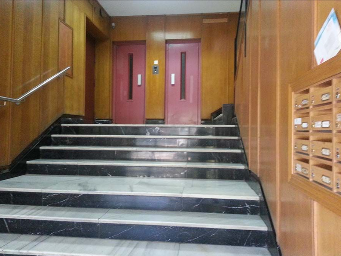 Un conjunto de escaleras que conducen a dos ascensores en un edificio.