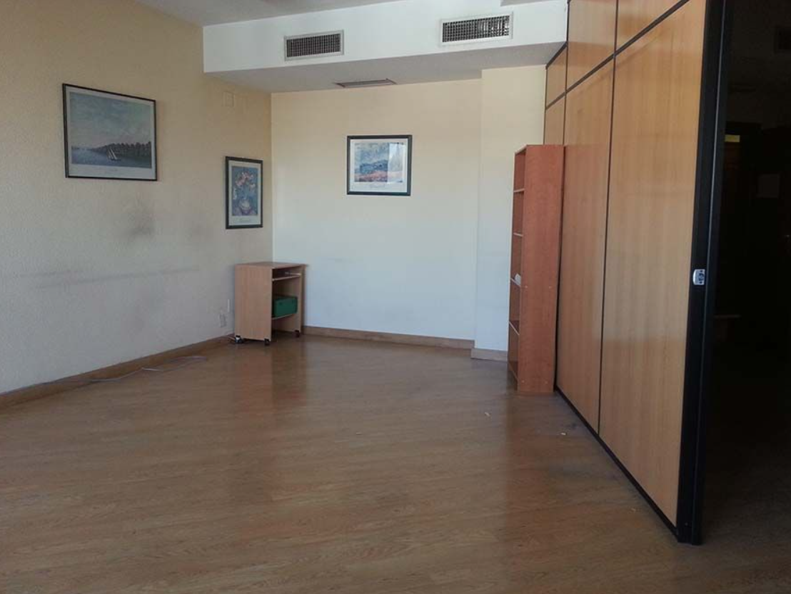 Una habitación vacía con suelo de madera y paredes blancas.