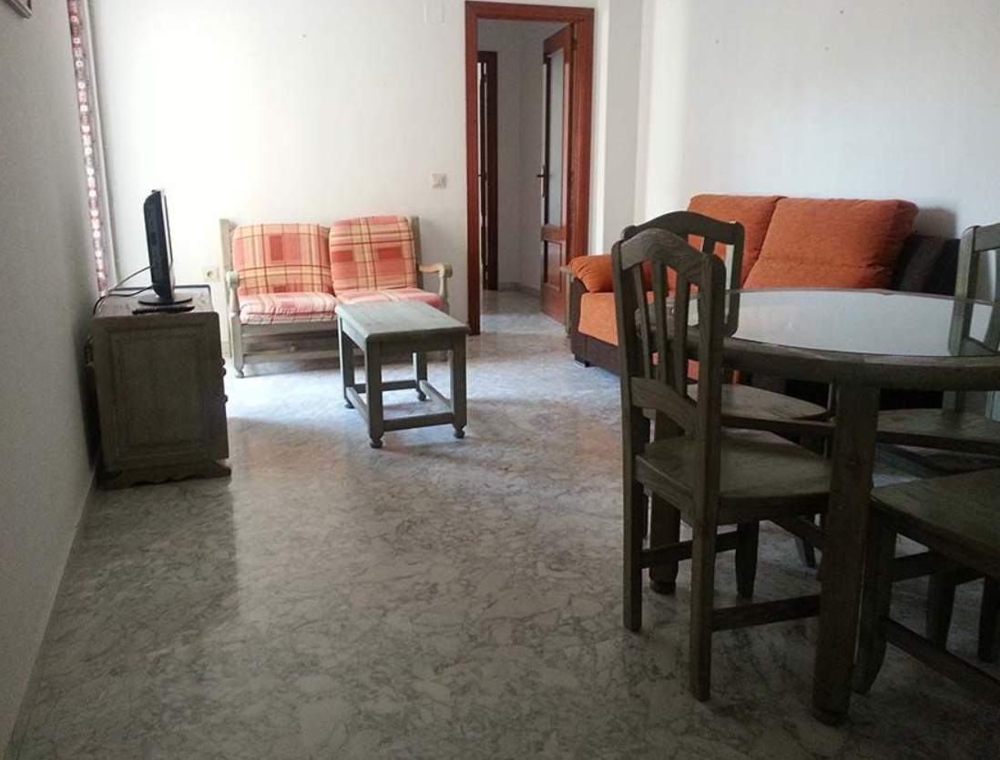 Una sala de estar con un sofá, una mesa y sillas.