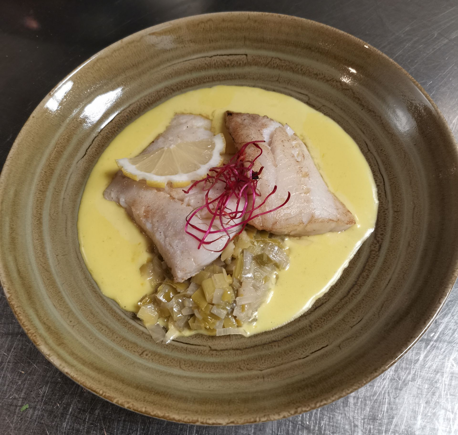 Filets de poisson avec sauce, tranche de citron et garniture