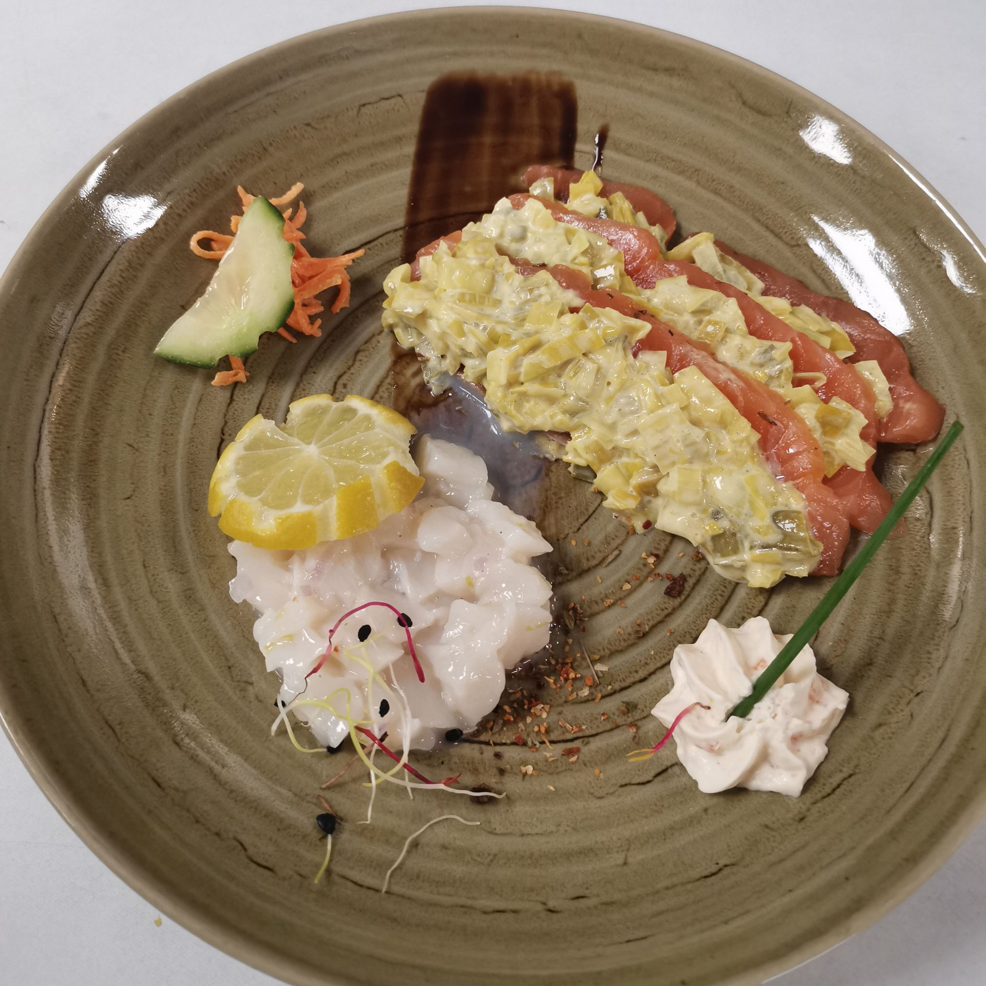 Assiette de poisson, fruits de mer, citron et sauce, avec garnitures.