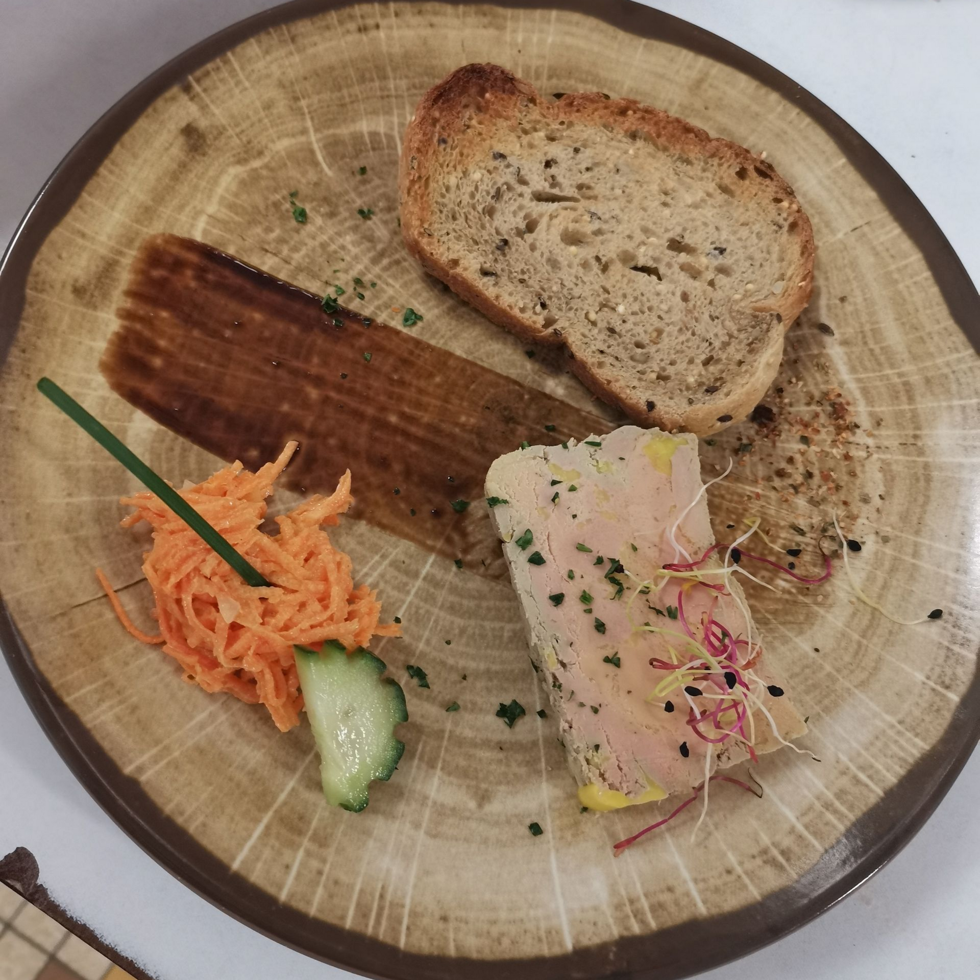 Foie gras et pain sur une assiette en bois rustique