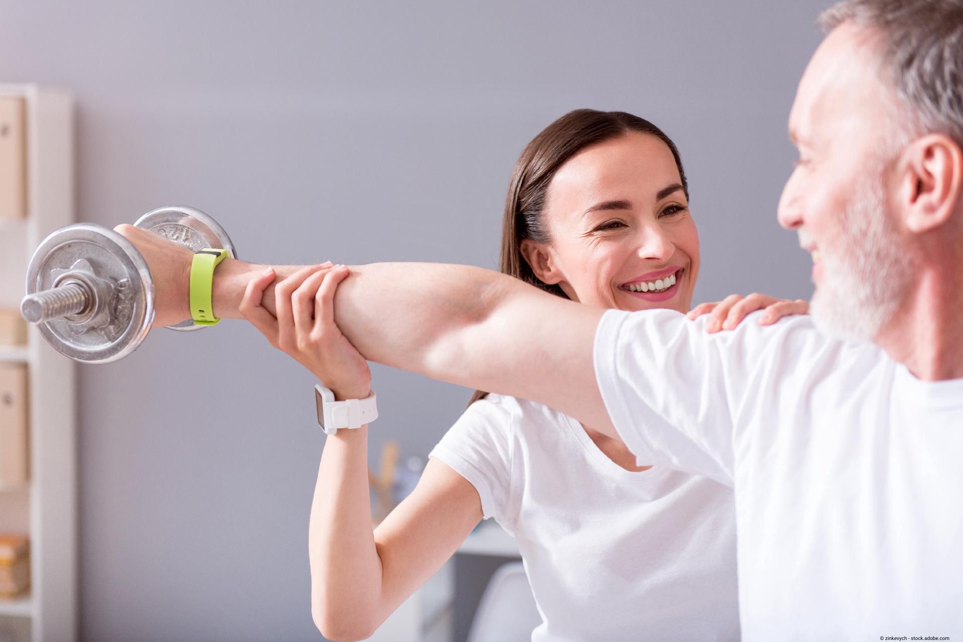Therapeutin unterstützt einen Mann beim gezielten Armtraining mit Gewichten in der Physiotherapie.