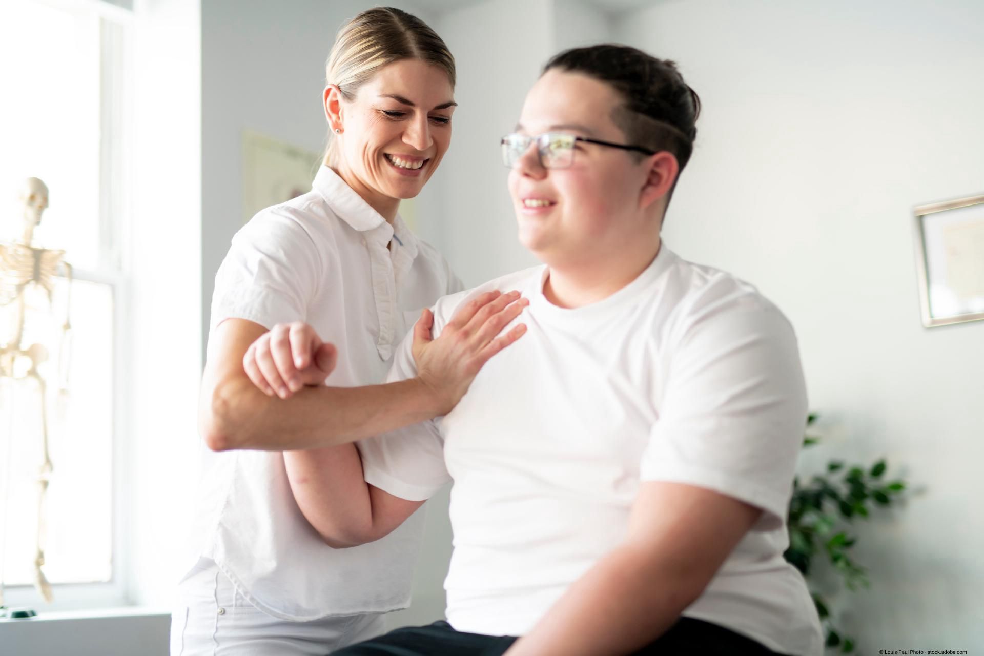 Therapeutin unterstützt Patienten bei einer Übung zur Verbesserung von Haltung und Bewegung.