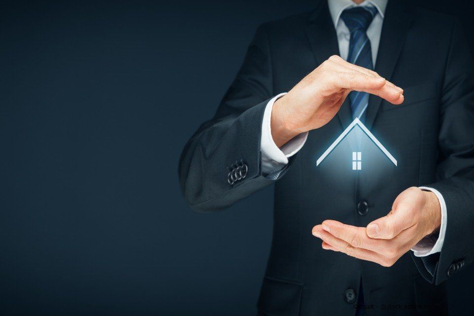 Ein Mann hält ein beleuchtetes Hausmodell