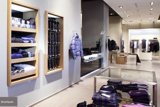 Intérieur de magasin de vêtements avec spots encastrés au plafond.