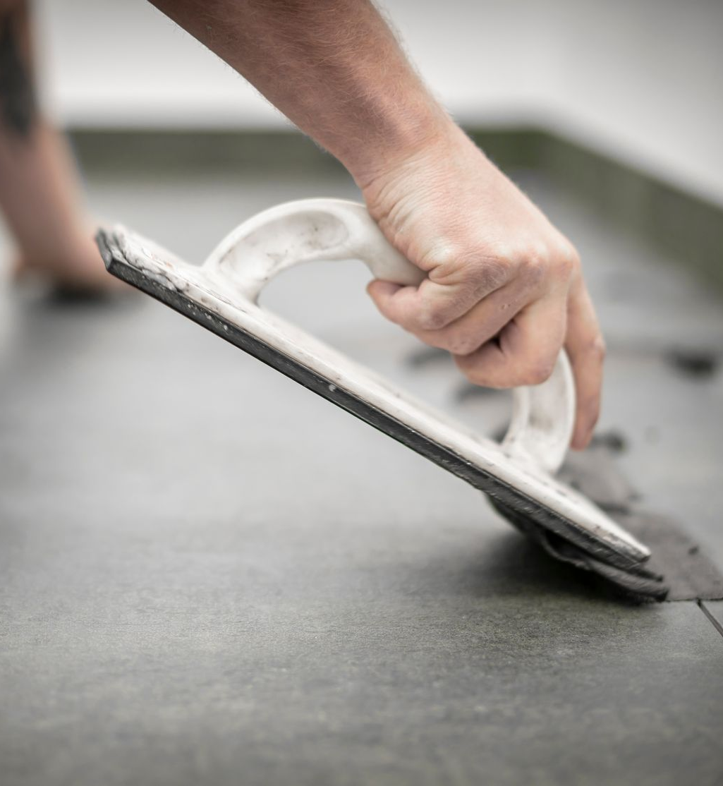 Lissage manuel du joint entre les carreaux de carrelage.