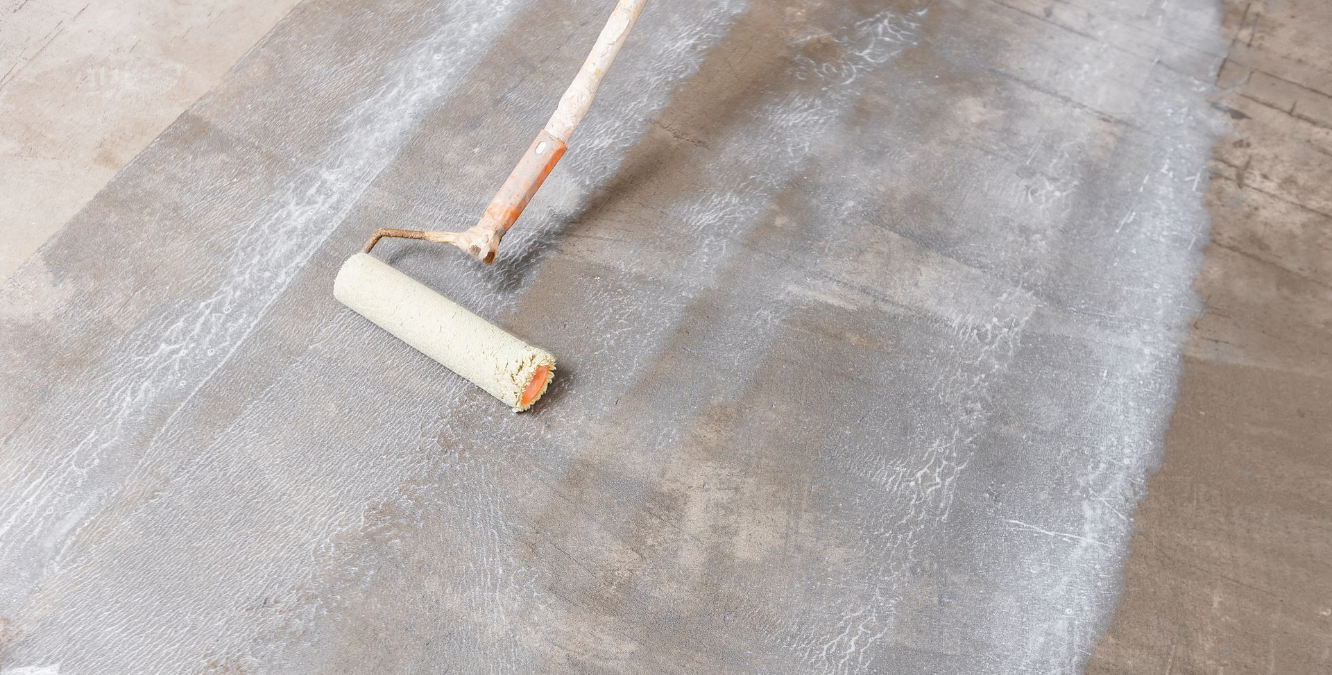 Application d'un primaire d'accrochage sur le sol.