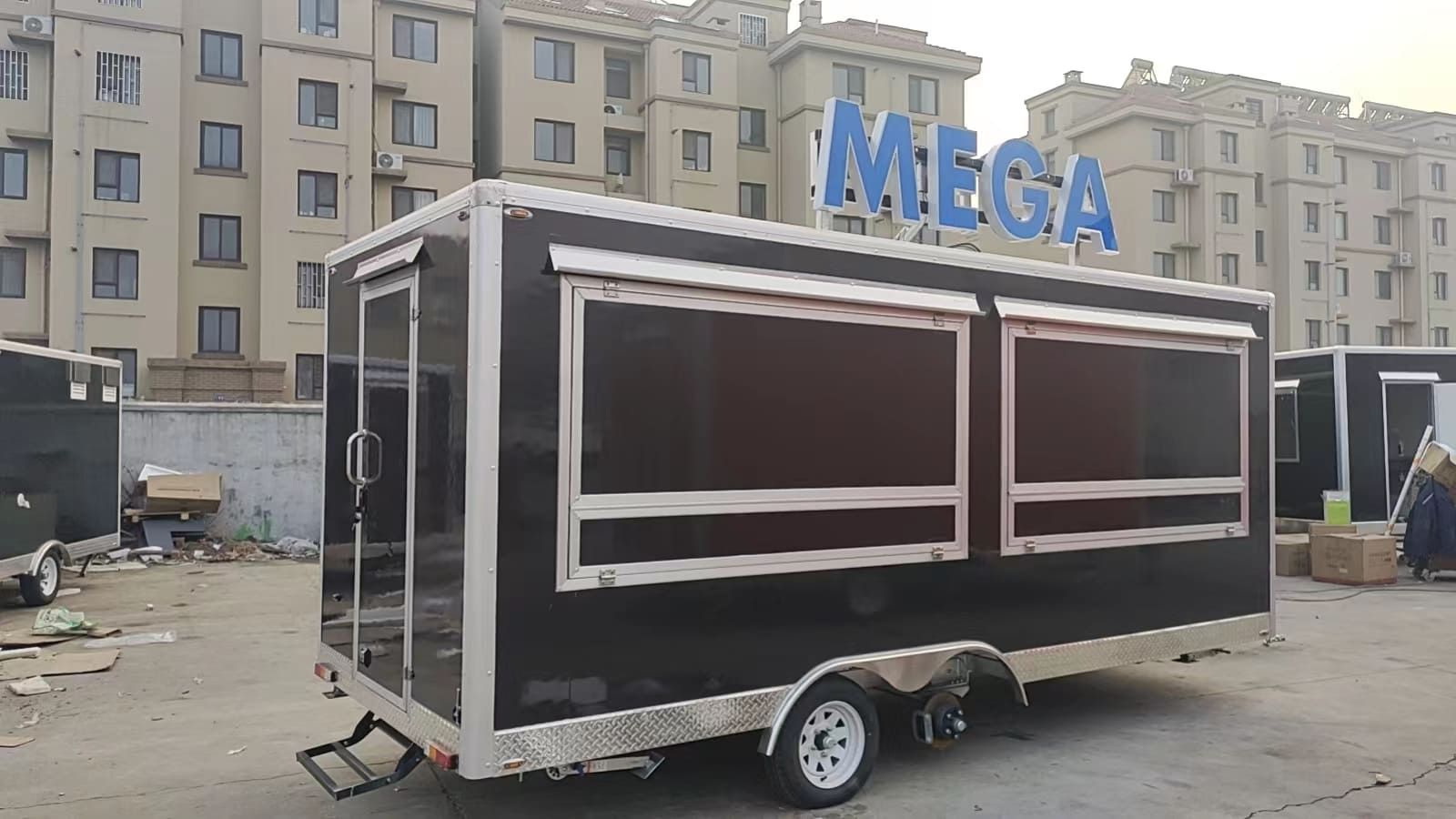 Un camión de comida está estacionado en un estacionamiento frente a un edificio.