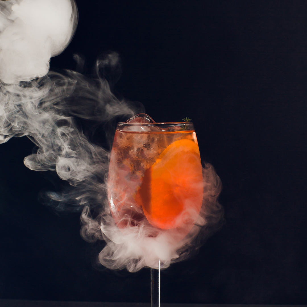 Un vaso de jugo de naranja del que sale humo.