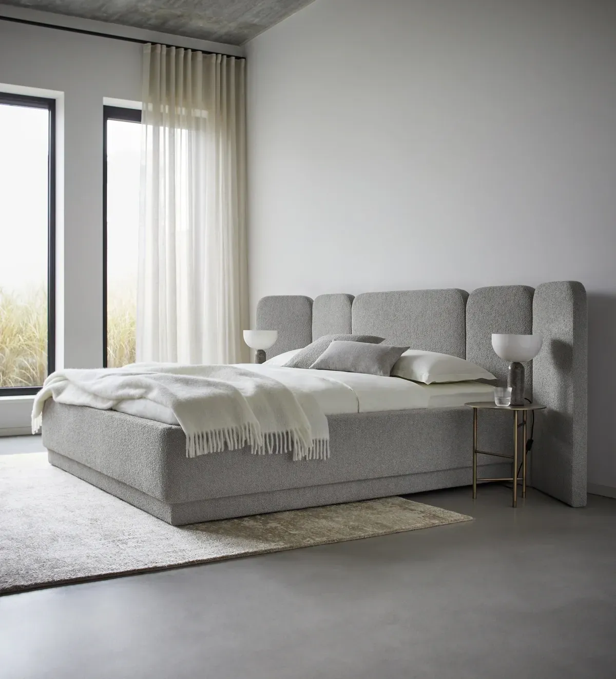 Ein Schlafzimmer mit großem Bett und zwei Fenstern