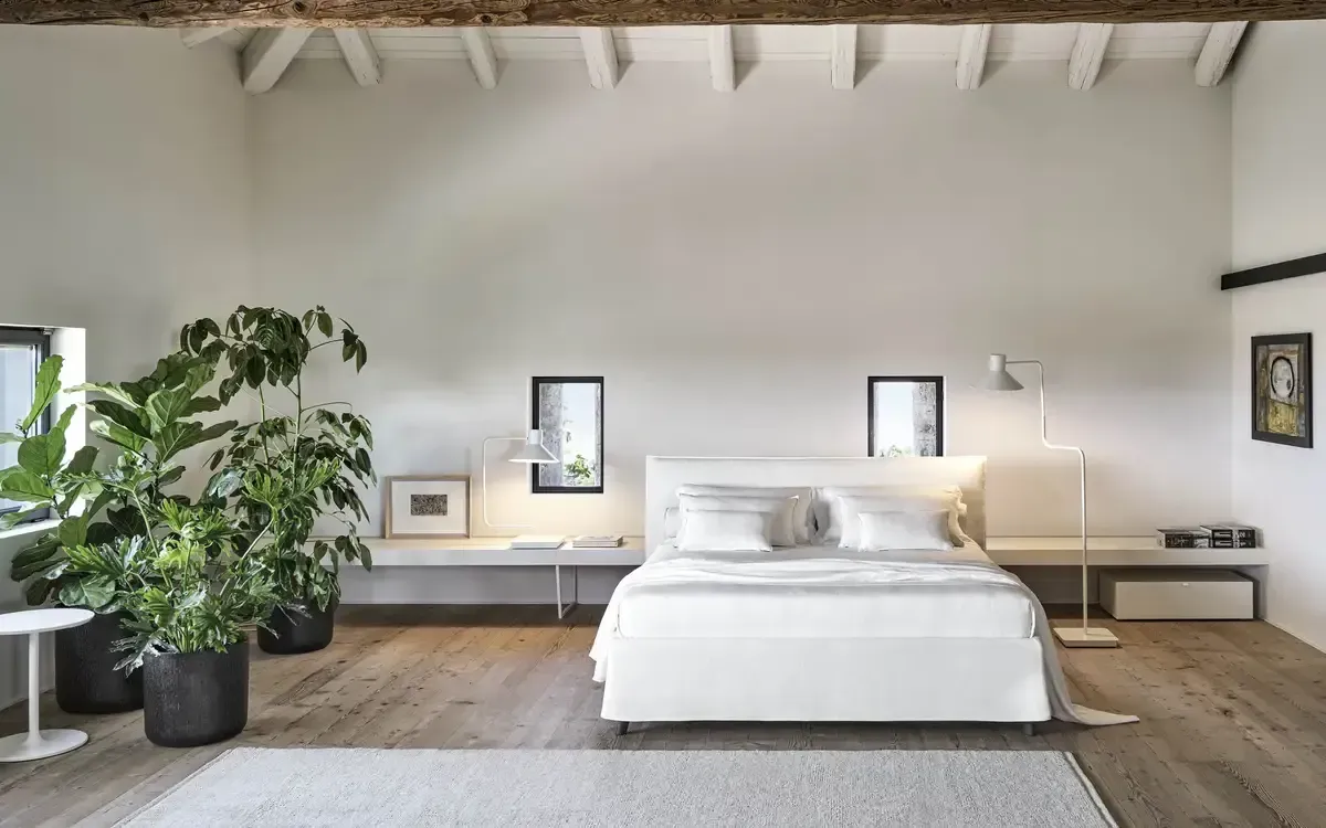 Ein Schlafzimmer mit Bett und Topfpflanzen