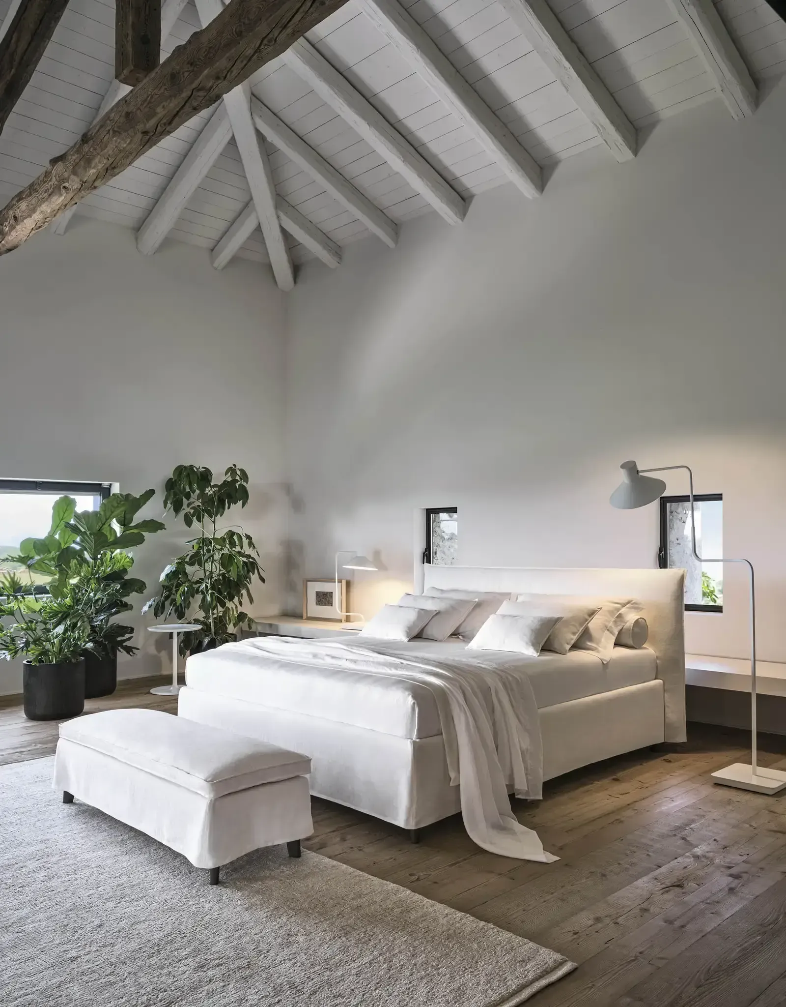 Ein Schlafzimmer mit großem Bett und Sitzbank