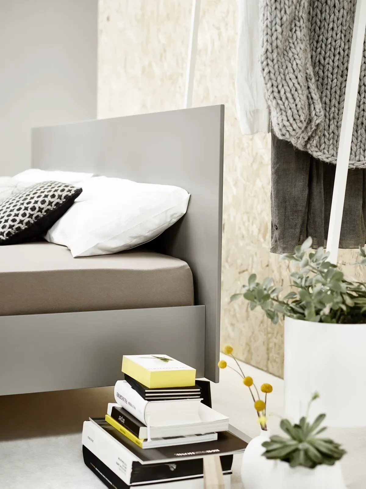 Ein Bett mit einem Stapel Bücher auf der Seite