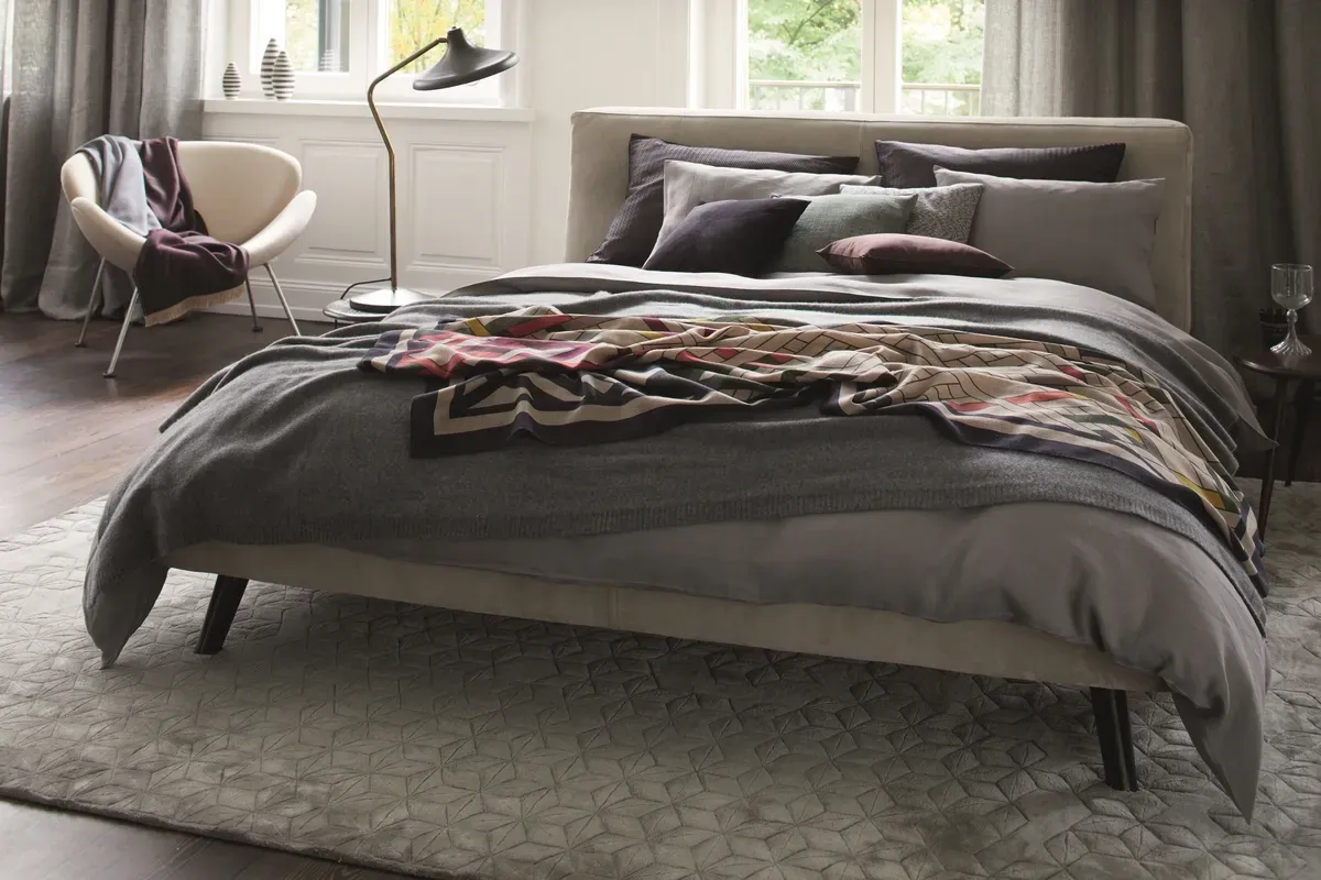 Ein Schlafzimmer mit Bett, Stuhl und Lampe