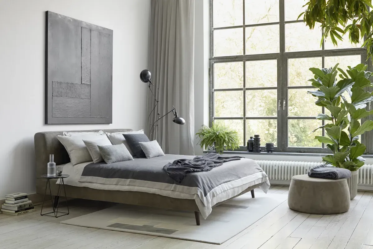 Ein Schlafzimmer mit großem Bett und großem Fenster.