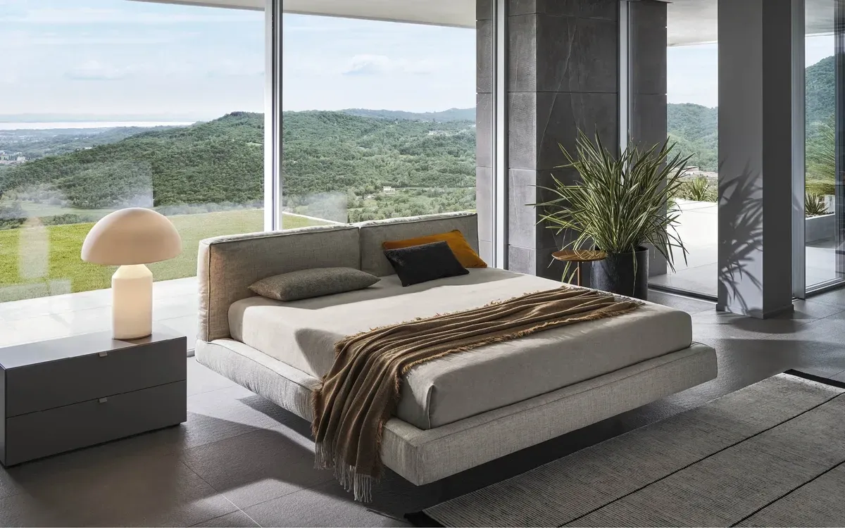 In der Mitte des Zimmers steht ein großes Bett mit Blick auf die Berge.