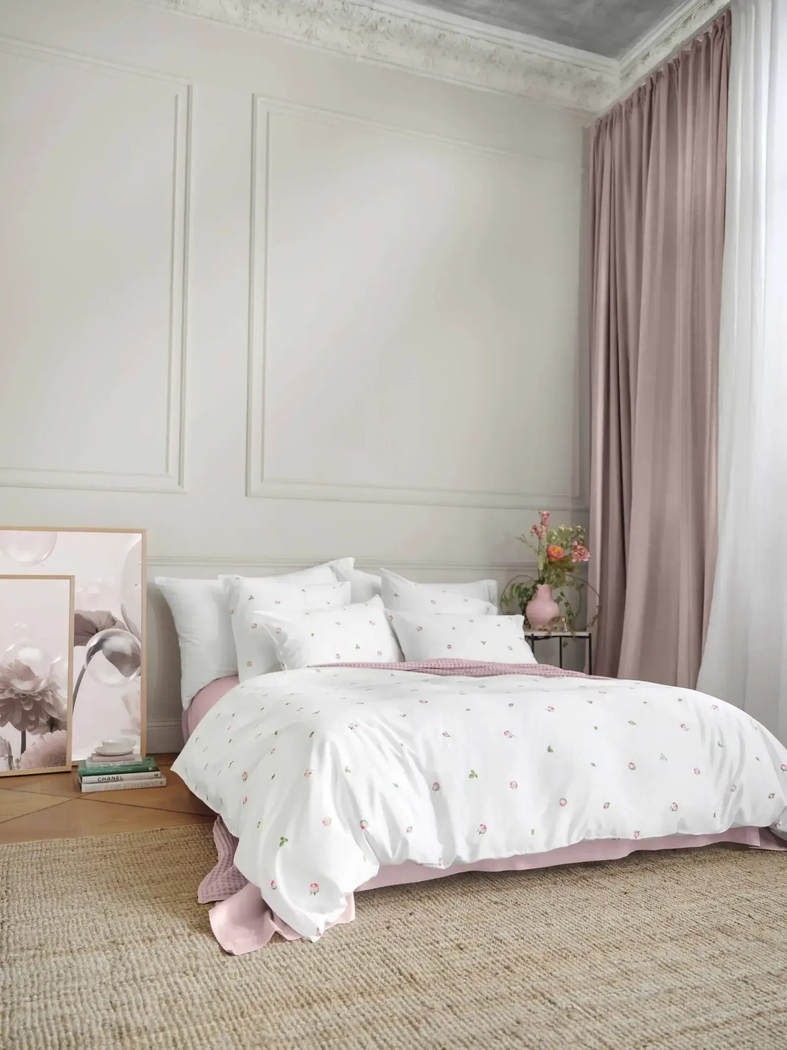 Ein Bett mit einer weißen Bettdecke und rosa Kissen in einem Schlafzimmer.