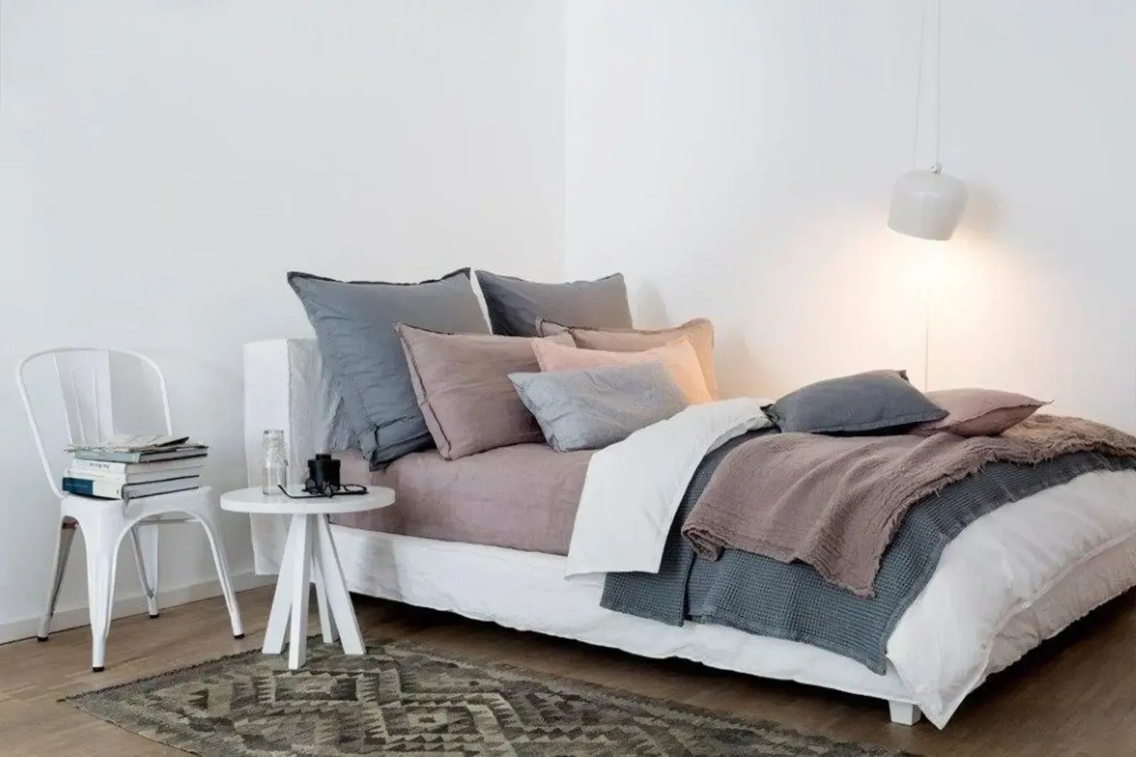 Ein Schlafzimmer mit Bett, Stuhl, Tisch und Teppich.