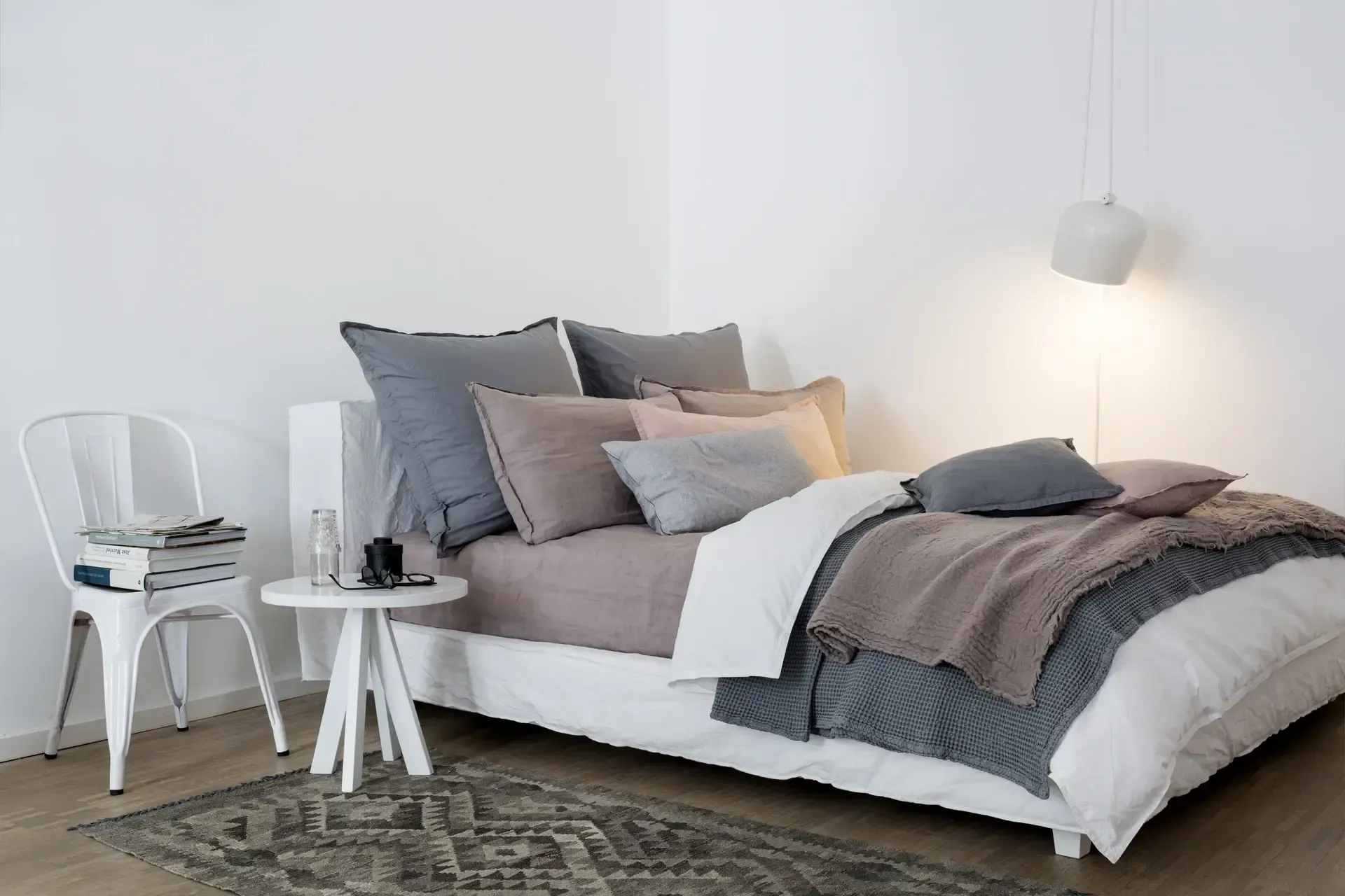 Ein Schlafzimmer mit Bett, Stuhl, Tisch und Teppich.