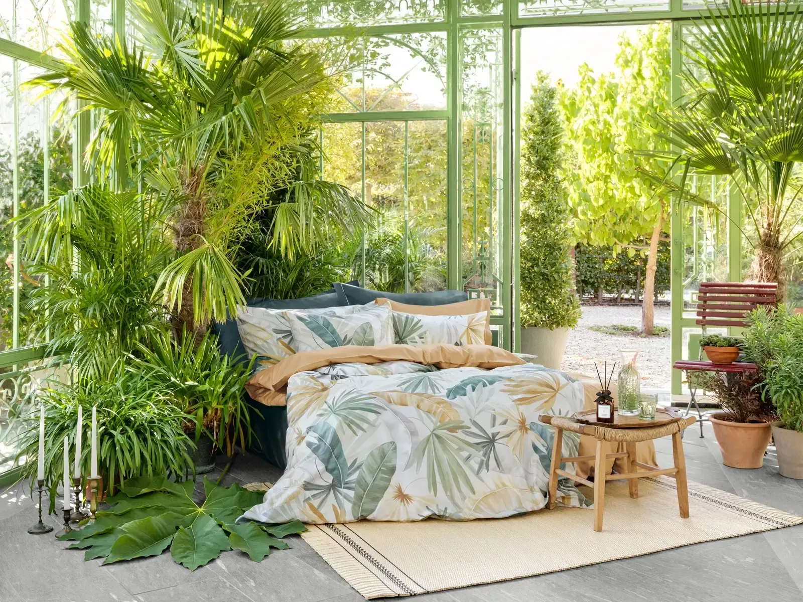 In der Mitte eines Gewächshauses steht ein Beet, umgeben von Pflanzen.