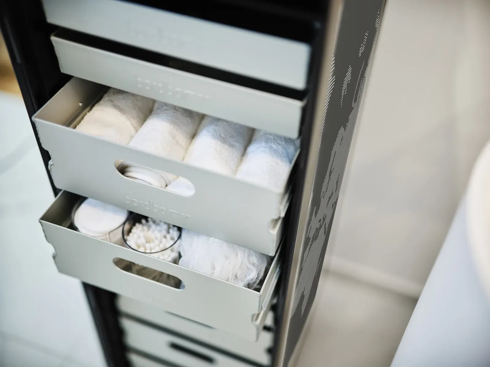 Eine Reihe von Schubladen voller Handtücher in einem Badezimmer.