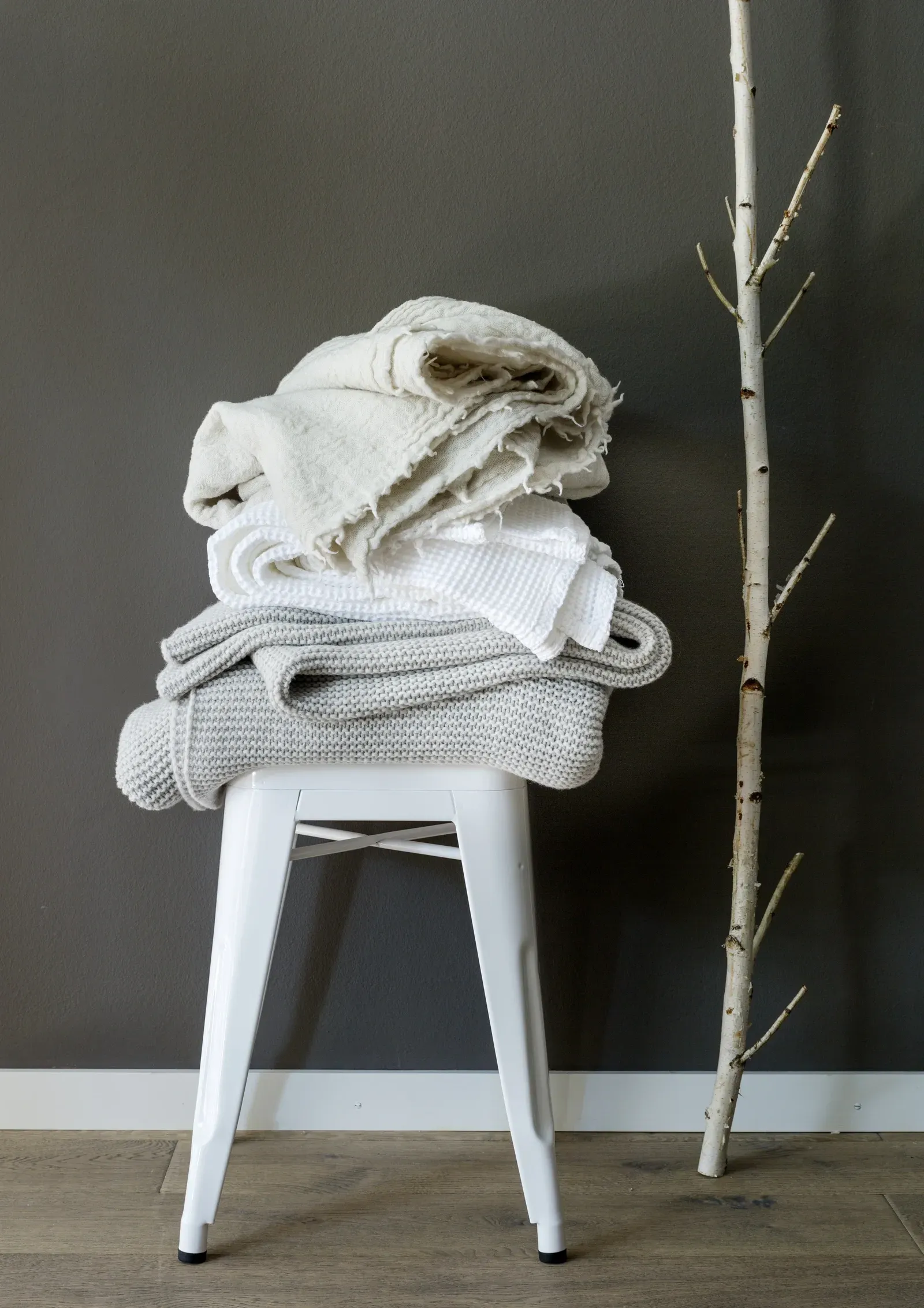 Ein weißer Hocker mit einem Stapel Decken darauf