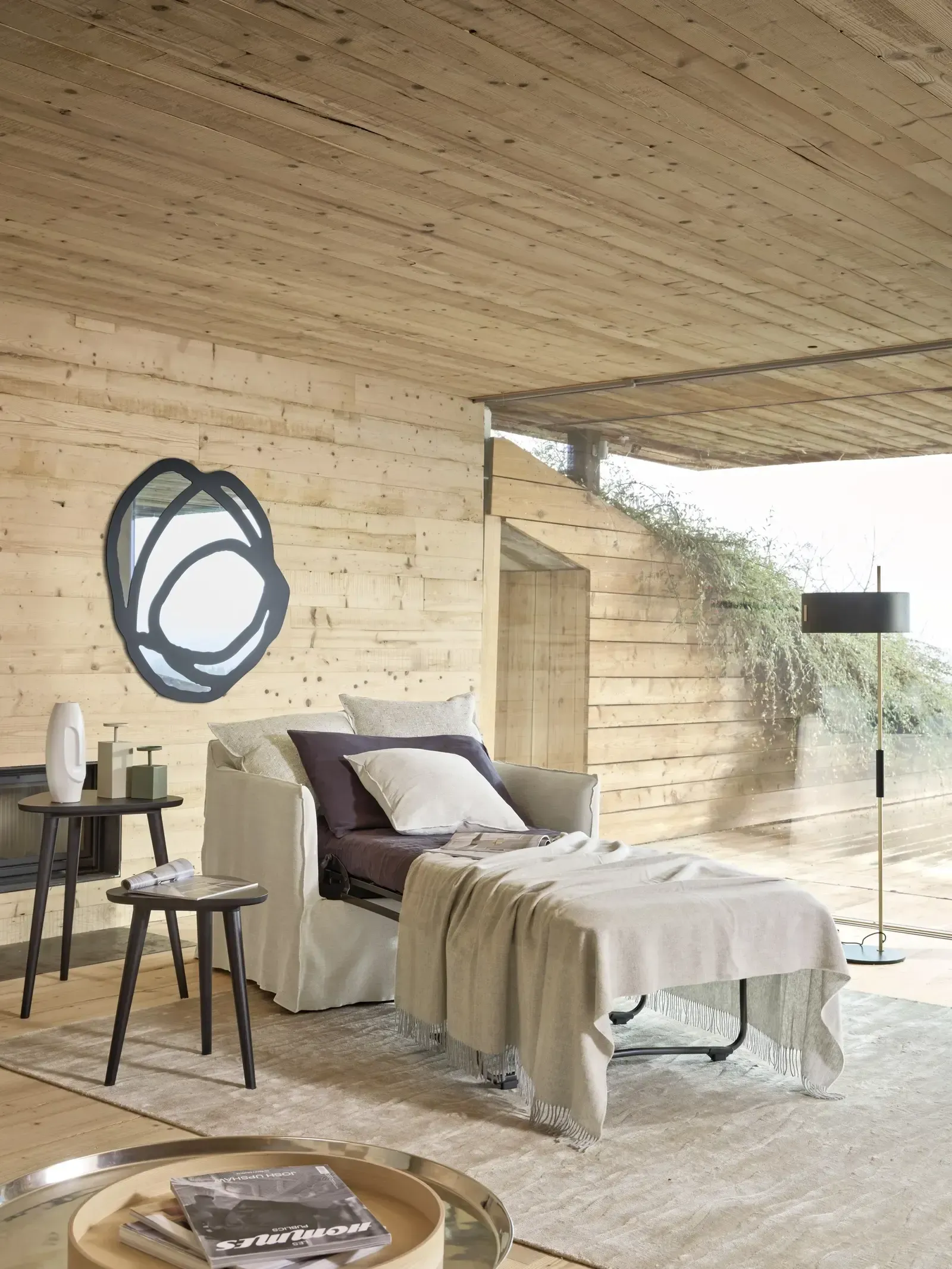 Ein Wohnzimmer mit einer Couch und Ottomane und einem Spiegel an der Wand