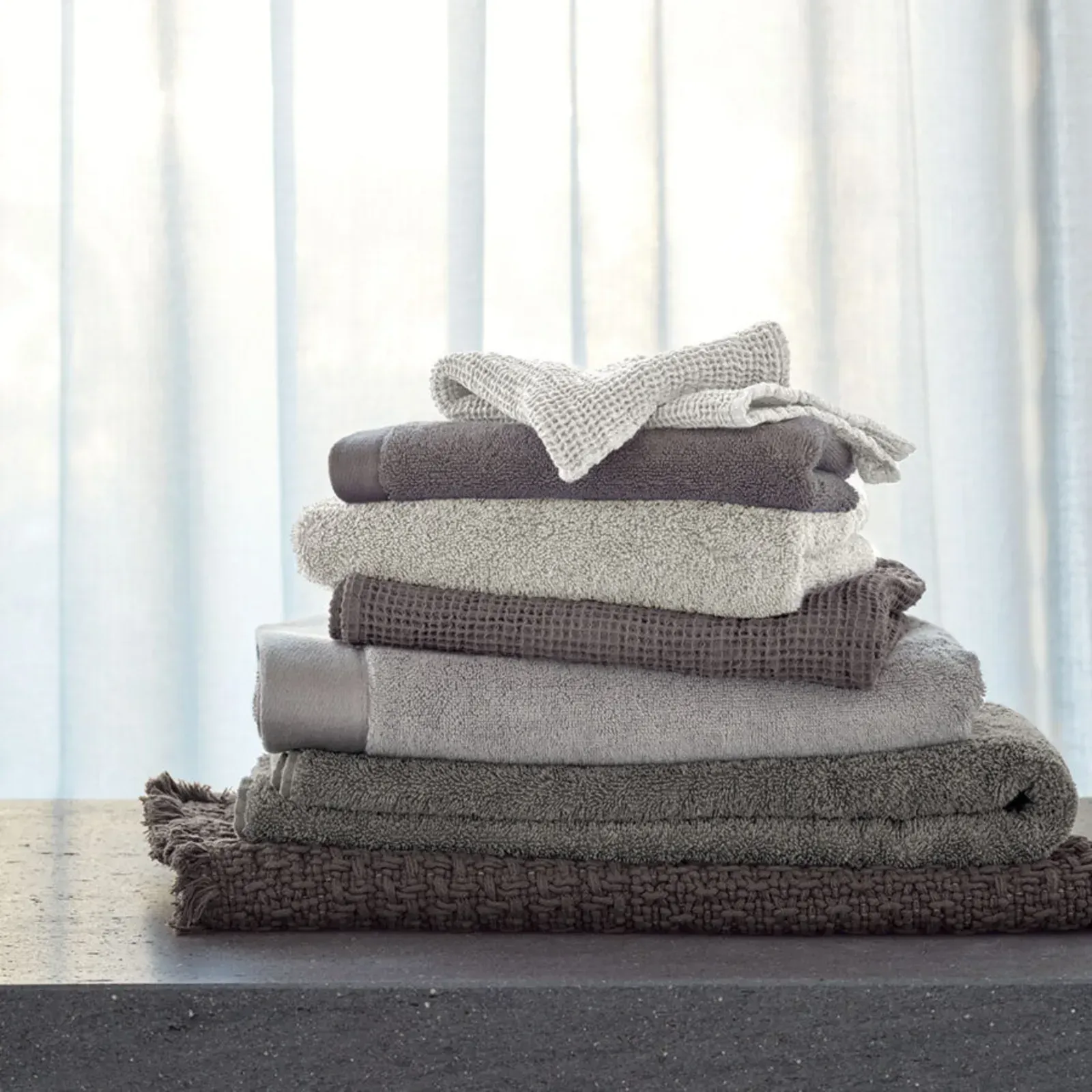 Ein Stapel Handtücher, die übereinander auf einem Tisch liegen.