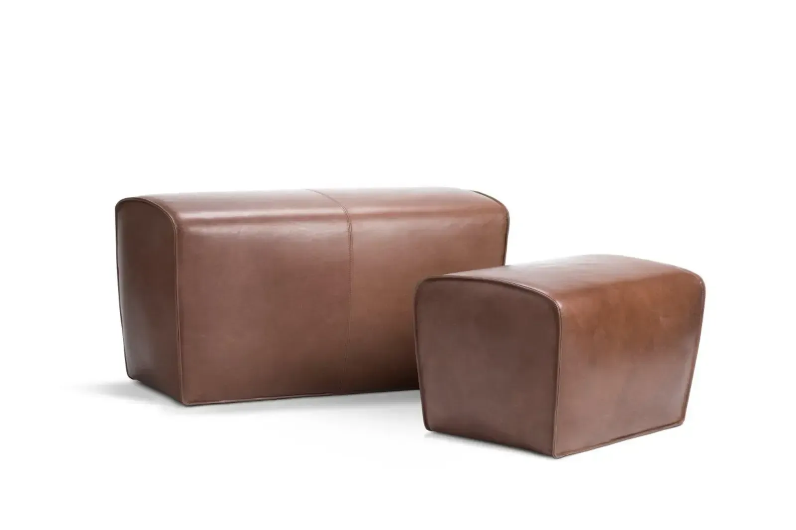 Zwei braune Lederhocker stehen nebeneinander auf einem weißen Hintergrund.