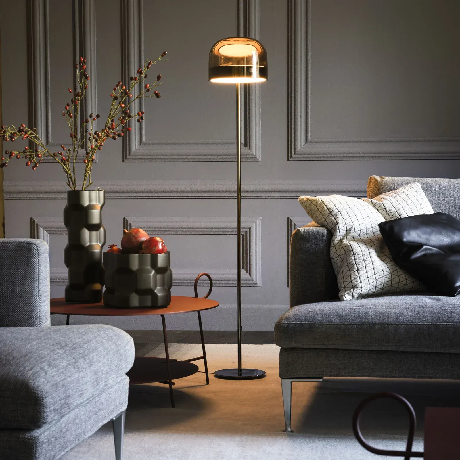 Ein Wohnzimmer mit einer Couch, einem Sessel und einer Lampe