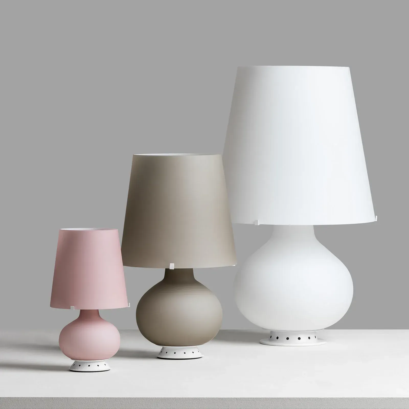 Drei Lampen mit unterschiedlichen Schirmen stehen auf einem Tisch