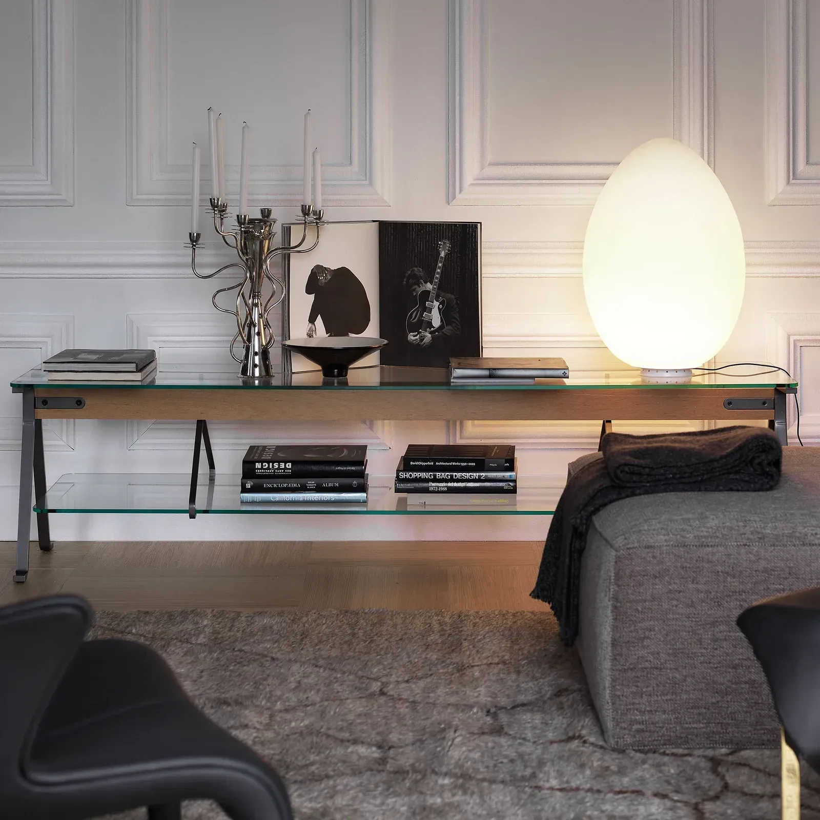 Ein Wohnzimmer mit einem Glastisch und einer Lampe