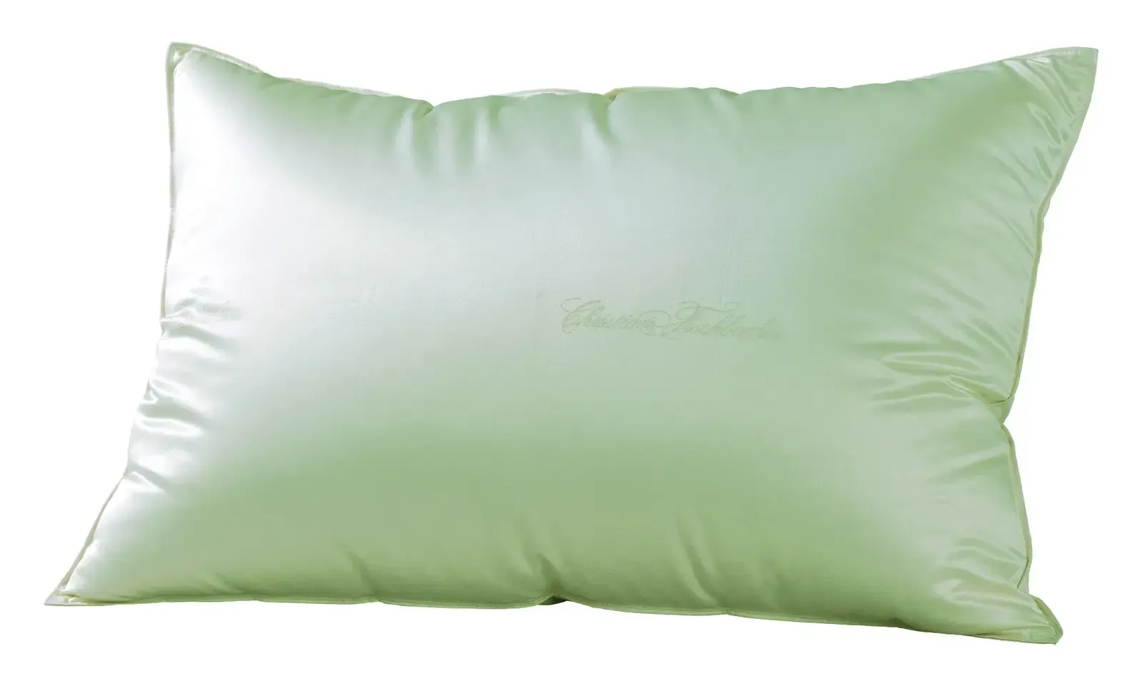 Ein grünes Kissen liegt auf einer weißen Fläche.