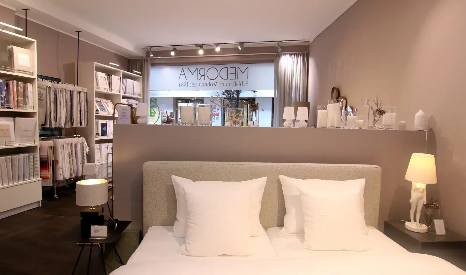 Ein Schlafzimmer mit einem Bett und Kissen vor einem Laden.