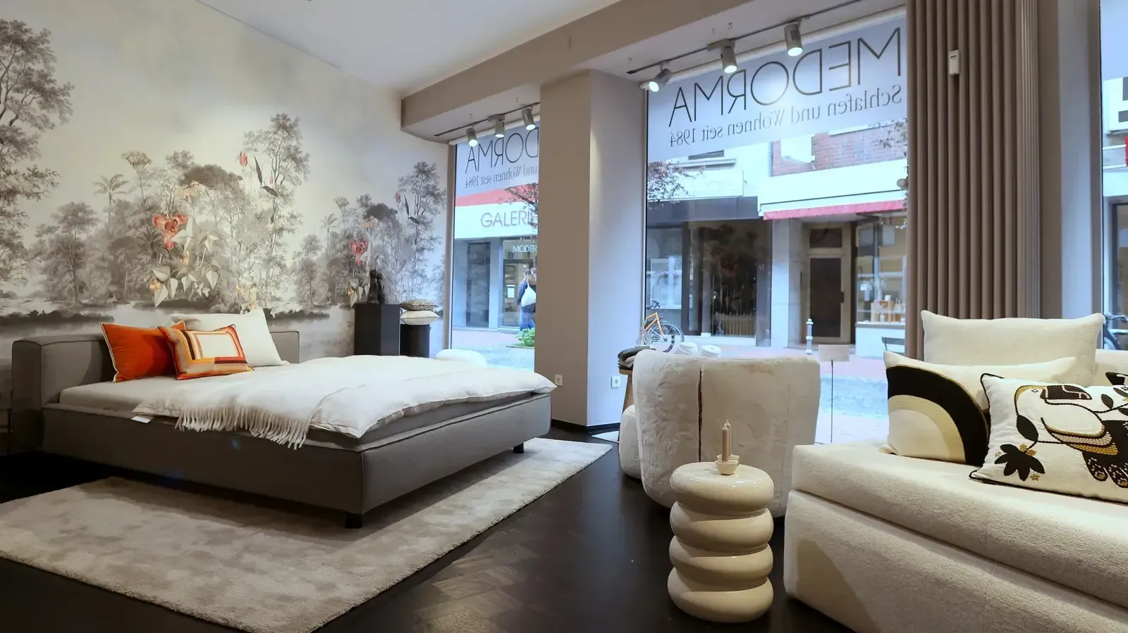 Ein Schlafzimmer mit einem großen Bett und einer Couch in einem Laden.