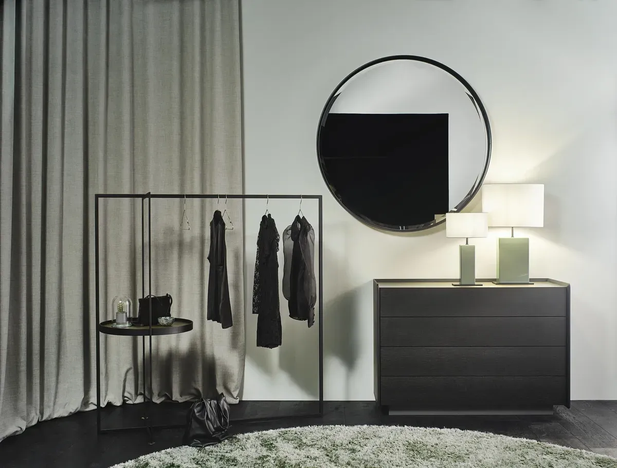 Ein Zimmer mit einer Kommode und einem Spiegel an der Wand