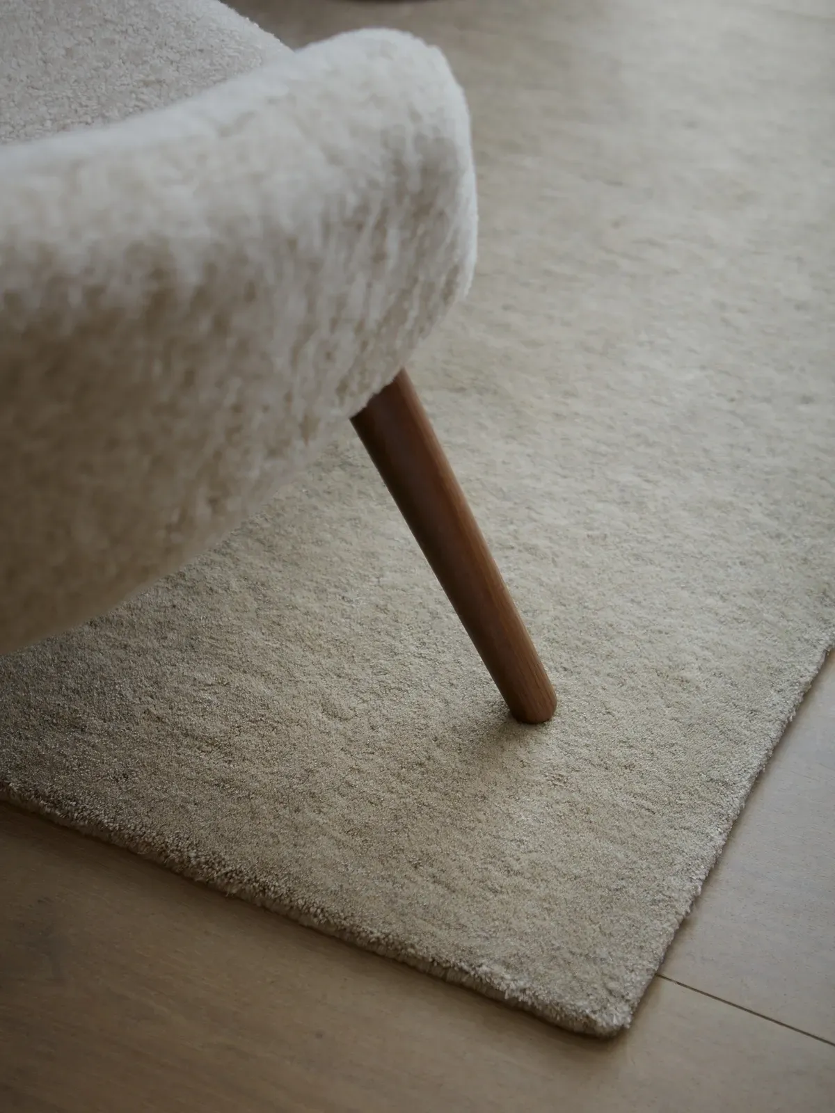 Ein Stuhl steht auf einem Teppich neben einem Teppich.