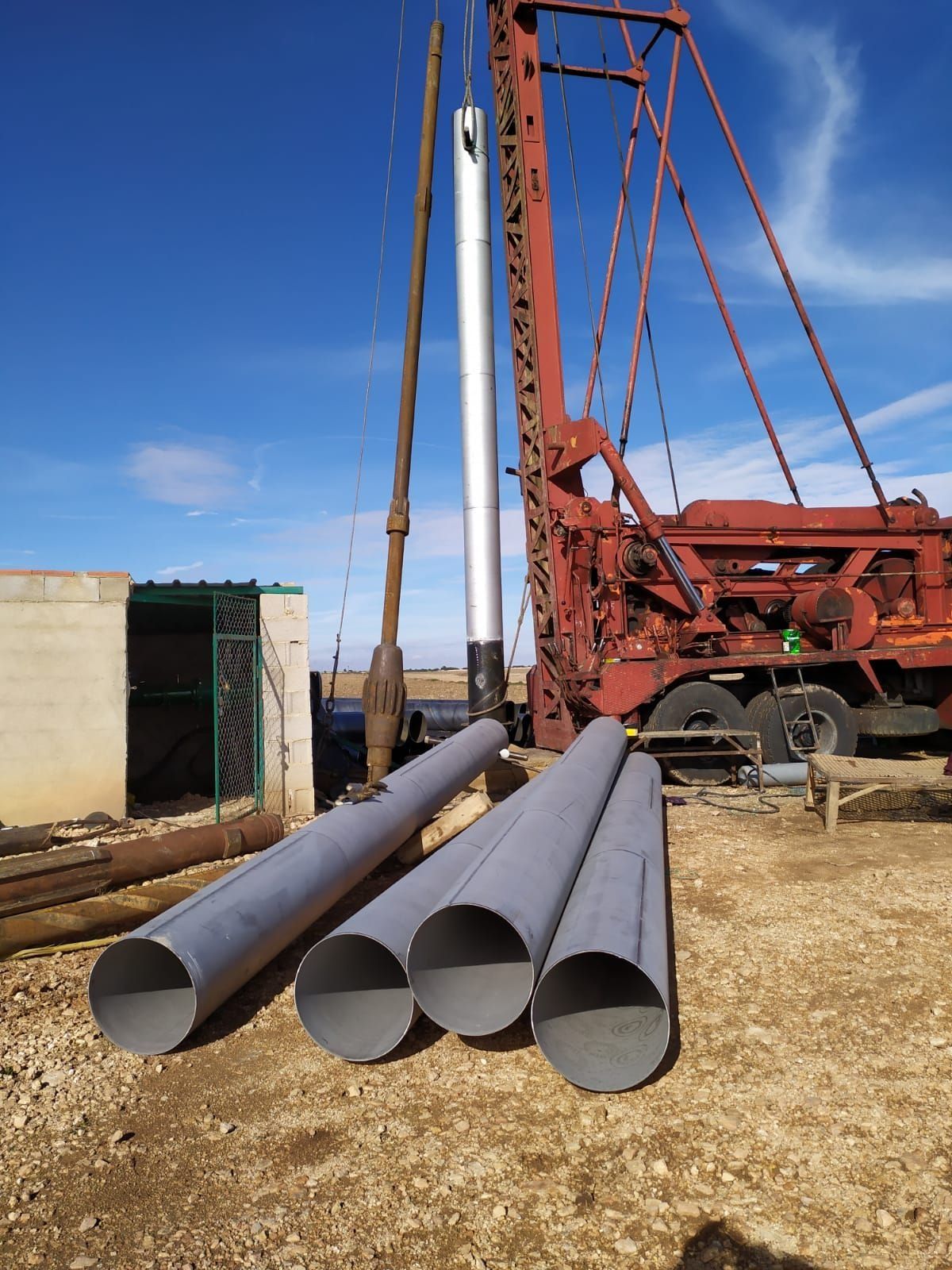 Tres tubos se apilan uno encima del otro delante de una grúa