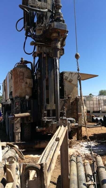 Una gran máquina está sentada encima de un campo de tierra.