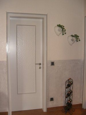 Weiße Zimmerwand mit einer weißen Tür