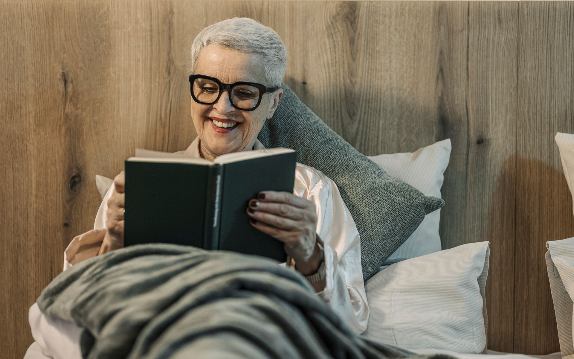 Eine Dame liest ein Buch in einer Junior Suite des MY MAYR MED Resorts.